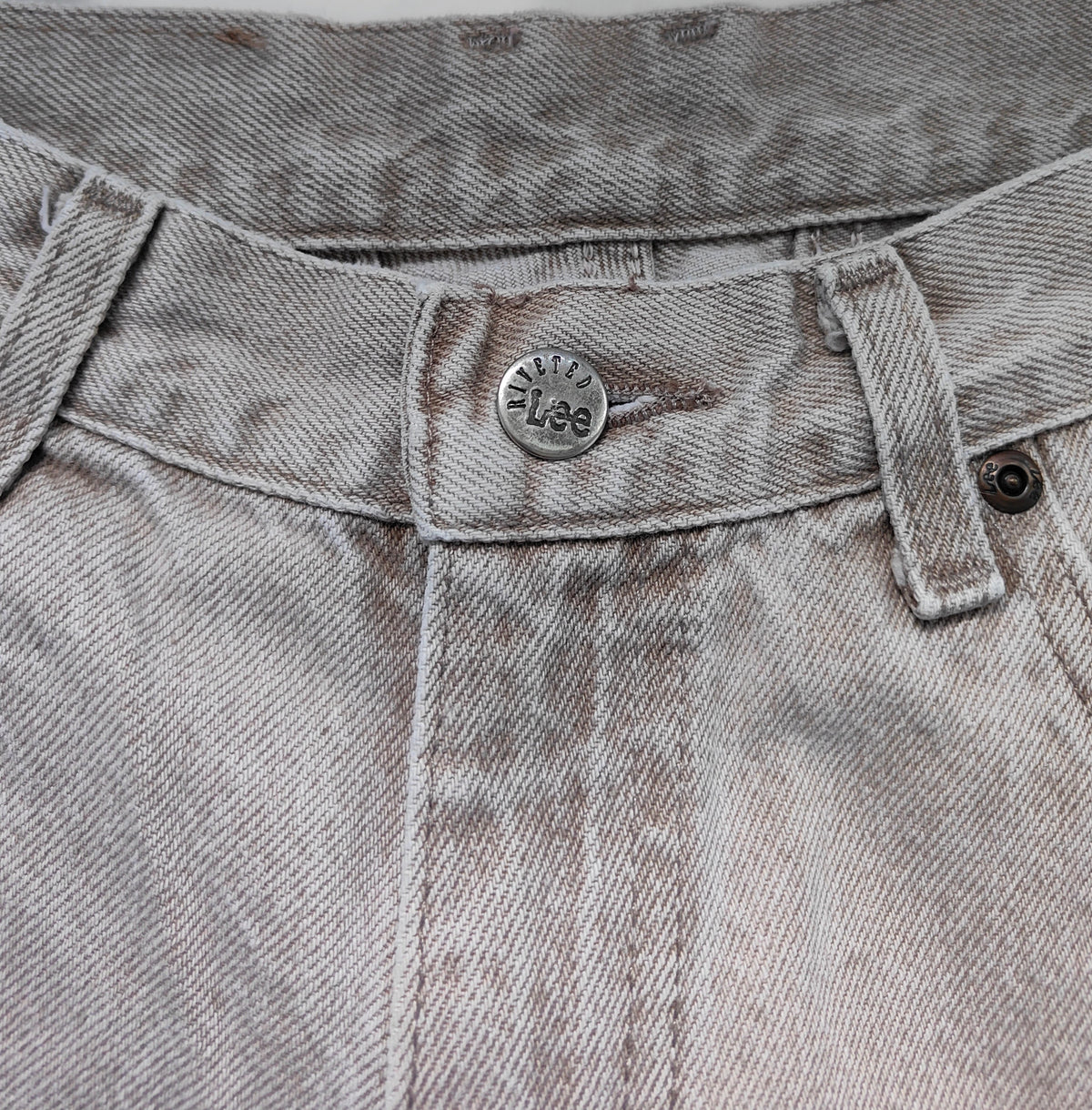 Close-up of Lee leather back patch and pocket on pale grey-taupe jeans